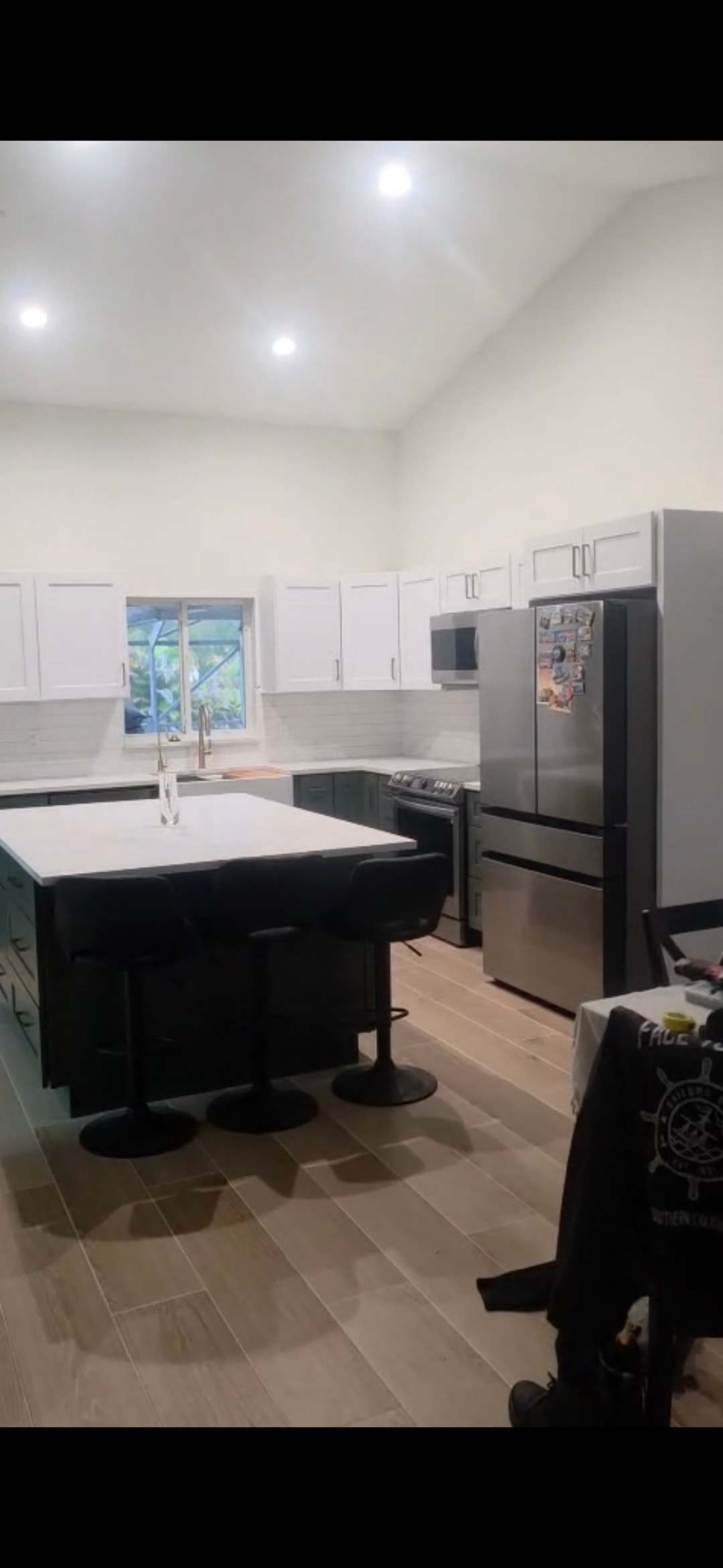 Completed kitchen renovation — white cabinets, quartz countertops, stainless appliances
